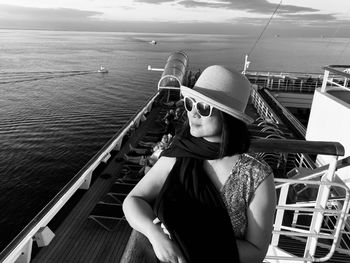 Mature woman standing on boat deck against sea