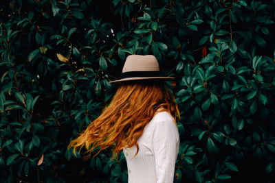 Rear view of woman standing by plants