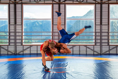 Greco-roman wrestling training, grappling. two greco-roman wrestlers in red and blue uniform