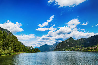 Scenic view of lake by mountains against sky