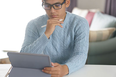 Midsection of man using mobile phone