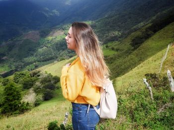 Side view of young woman standing on mountain