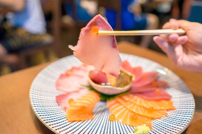 Close-up of hand holding ice cream in plate