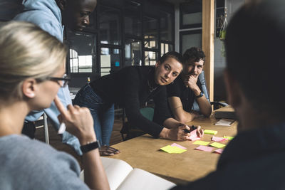 Female freelancer discussing with colleagues over start-up strategy at workplace