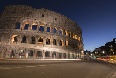 Low angle view of coliseum against sky at night