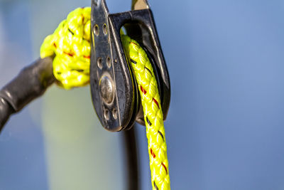 Close-up of rope hanging on metal against blue background