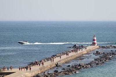 Group of people on beach against clear sky