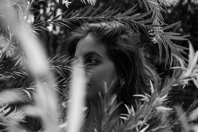 Close-up of woman looking away by plants