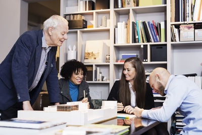 Happy multi-ethnic business people discussing about project in office