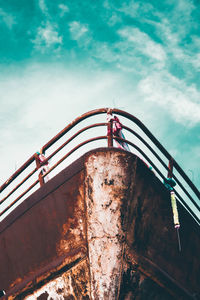 Low angle view of flag on bridge against sky