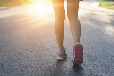 Low section of woman standing on road