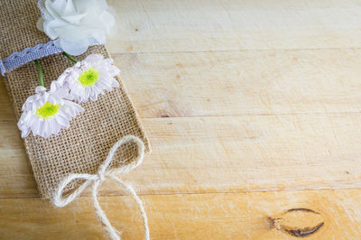 High angle view of flower and jute on table