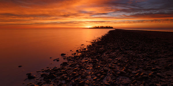 Scenic view of sea against orange sky