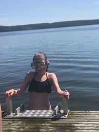 Girl standing on ladder in lake