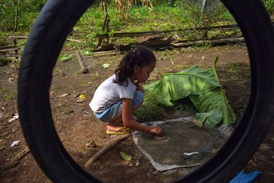 A girl with curly hair is playing in the backyard