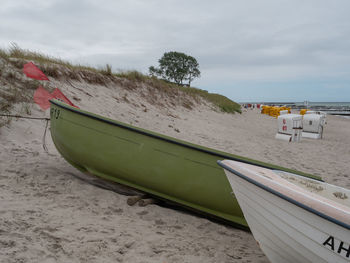 Boat moored on beach against sky