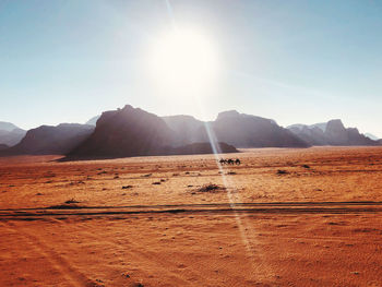 Scenic view of desert against sky on sunny day