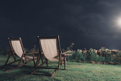 Chairs on field against sky