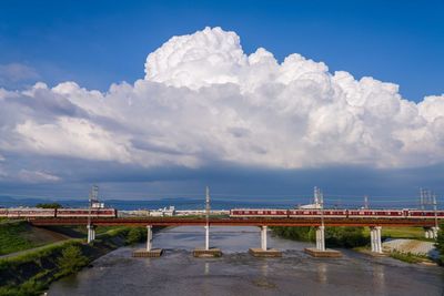 Bridge over sea against cloudy sky