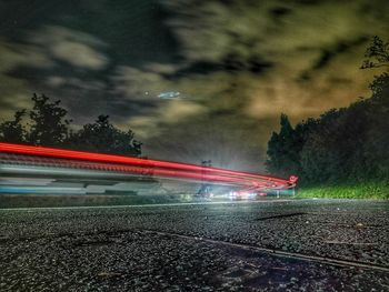 Light trails on car against sky at night