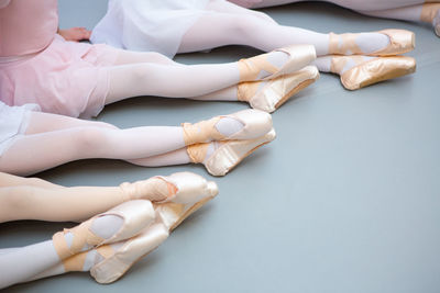 Low section of ballet dancers sitting on floor