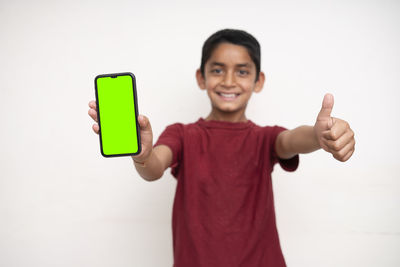 Portrait of smiling boy standing against white background