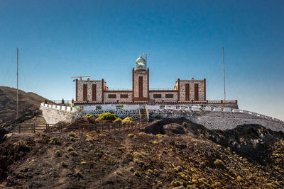 Historic building against blue sky, lighthouse, fuerteventura 