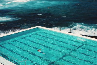 Man of swimming pool against calm sea