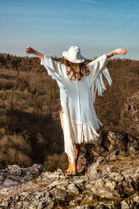 Rear view of woman standing on field