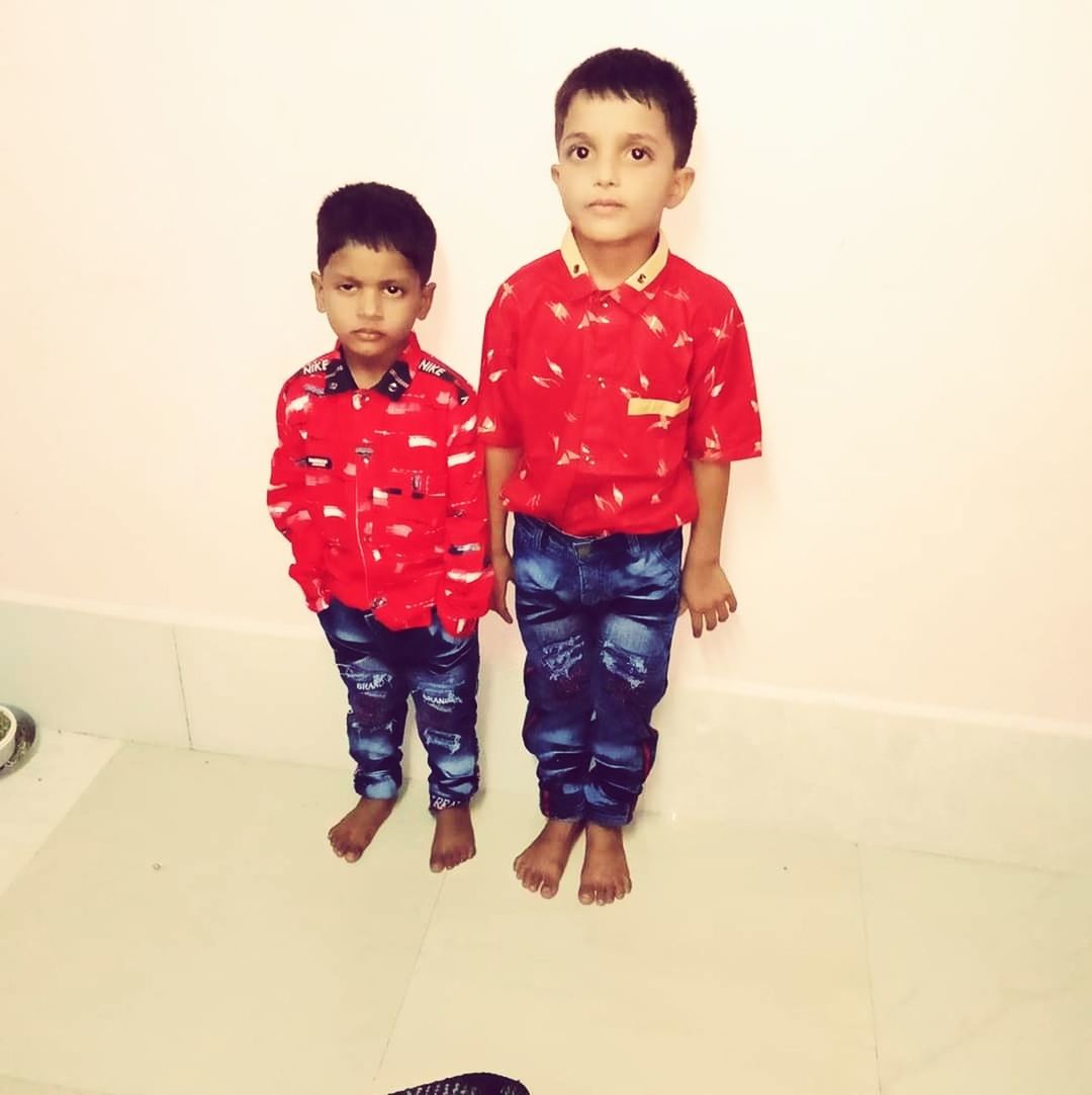 childhood, child, two people, indoors, boys, portrait, front view, full length, males, casual clothing, looking at camera, red, sibling, real people, family, innocence, men, togetherness, sister, flooring, tiled floor