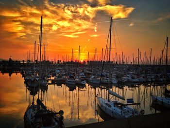 Boats moored at harbor during sunset