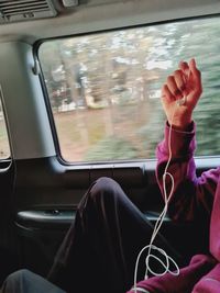 Midsection of woman listening music in car