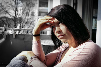 Thoughtful woman sitting in balcony