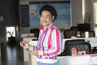 Portrait of a smiling young woman using smart phone