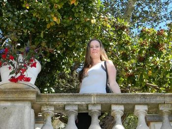 Portrait of young woman against plants