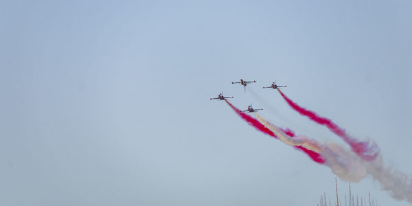 Low angle view of airshow against sky