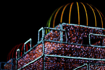 Low angle view of illuminated ferris wheel against sky at night