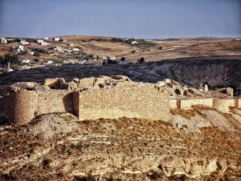 Stone wall on land against clear sky