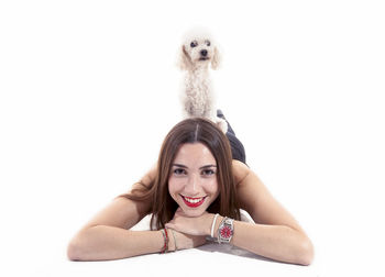 Portrait of young woman with dog against white background