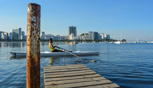 Man boating on lake in city