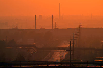 Factory against sky during sunset