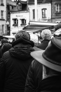 Rear view of people walking on street in city