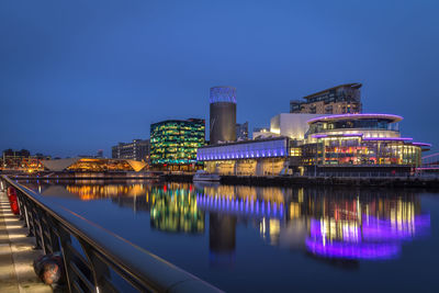 Illuminated bridge over river against sky at night