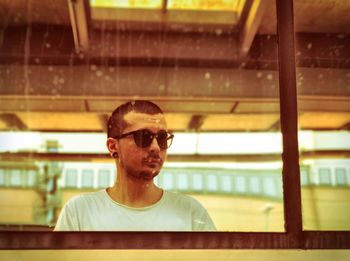 Young man in sunglasses reflecting on mirror