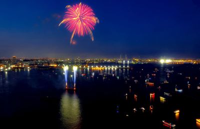 Firework display over illuminated buildings in city at night