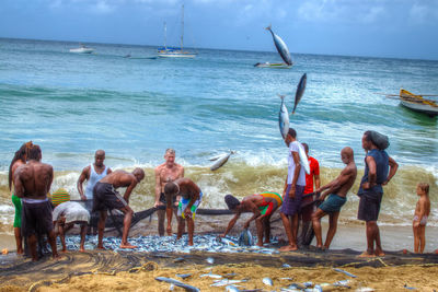 People at beach against sky