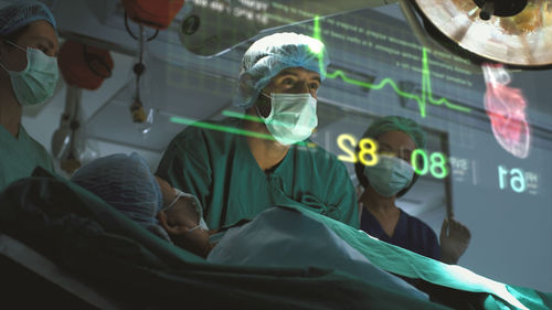 A surgeon diagnose a woman's heart problem via a holographic body scan before surgical procedure