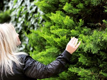 Woman touching plants in park