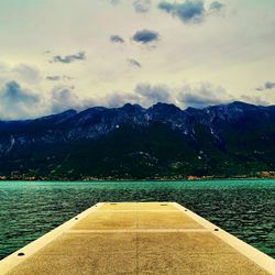 Scenic view of lake by mountains against sky