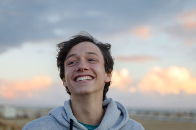 Portrait of smiling young man against sky during sunset
